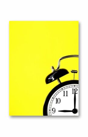 Black retro alarm clock at 9 nine o clock on a yellow background with copy space to add text 9am 9pm