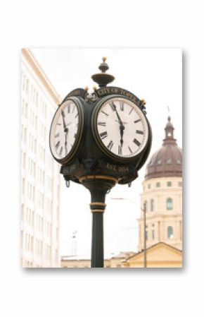 Topeka, Kansas, USA - June 17, 2023: Afternoon light shines on a historic clock tower in downtown Topeka.