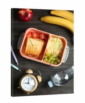 Lunch box with snacks, bottle of water, alarm clock and pens on wooden table, flat lay
