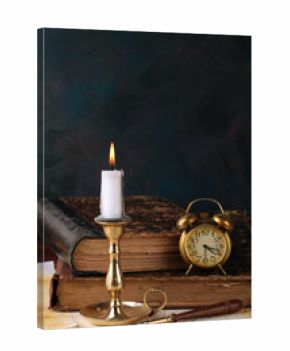 Candle with books and an alarm clock