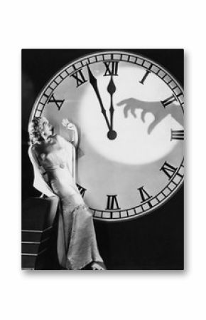 Woman with huge clock recoiling from frightening hand 