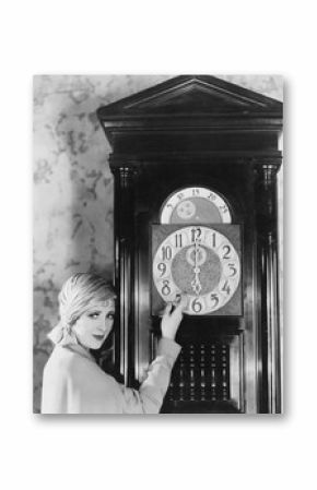 Woman with grandfather clock at midnight 