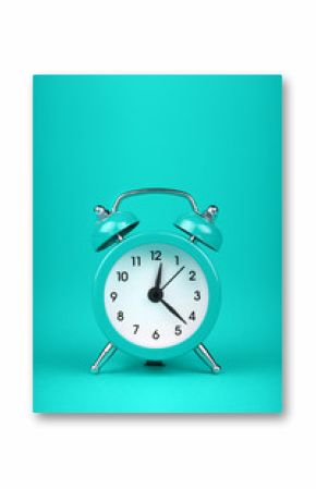 Close up one teal blue alarm clock over turquoise