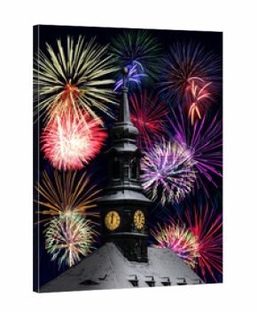 The clock on the town hall tower shows midnight, the background festive fireworks. A colorful fireworks at midnight to celebrate the New Year.