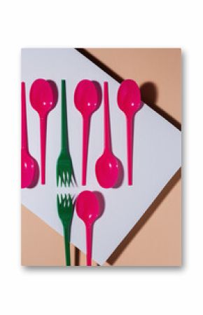 Overhead view of colorful eco friendly cutlery on pastel background