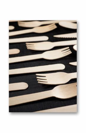 Disposable wooden cutlery on a black table.