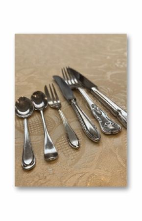 Row of elegant silver cutlery on a tablecloth.