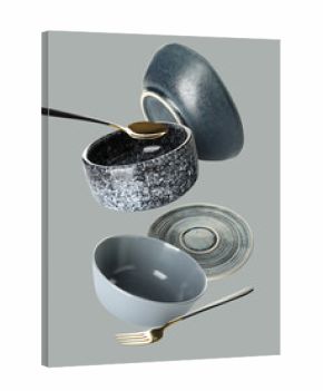 Flying clean dishes and cutlery on grey background