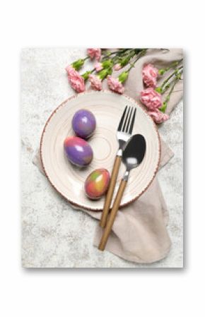 Table setting with Easter eggs, cutlery and carnation flowers on white grunge background