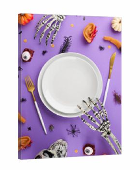 Spooky Halloween dinner idea. Top view of plates, cutlery, scary skull, skeleton hands, pumpkins, severed ears, fingers, eyeballs, spooky insects on purple background