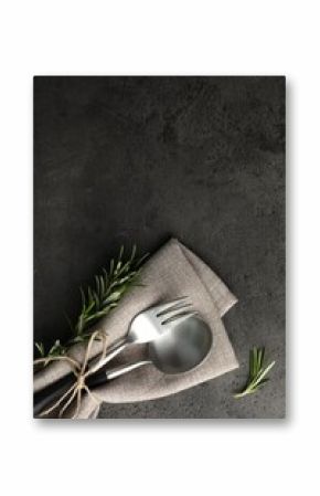 Stylish setting with cutlery and napkin on black table, top view. Space for text