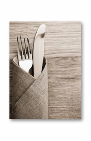 knife and fork at napkin on wood