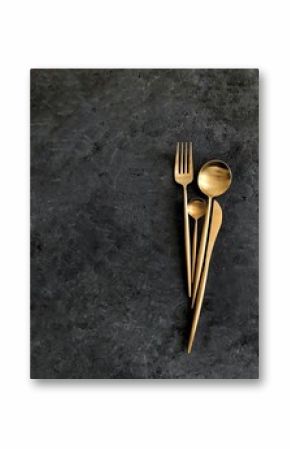 Golden cutlery on dark background