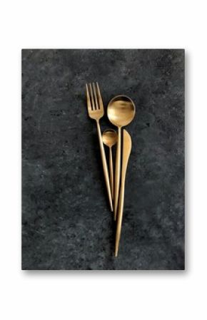 Golden cutlery on dark background