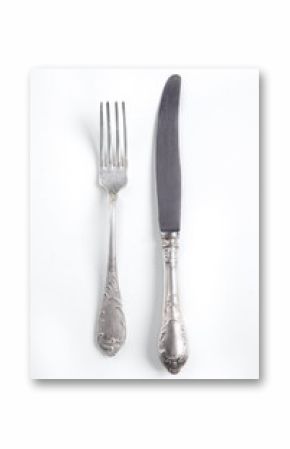 White vintage silver cutlery view from above on a white background. Top view..Antique knife and fork for a festive table for a wedding, birthday or party.