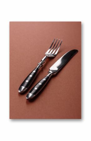 Knife and fork, cutlery on a brown dining table