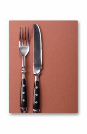 Knife and fork, cutlery on a brown dining table
