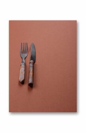 Knife and fork, cutlery on a brown dining table