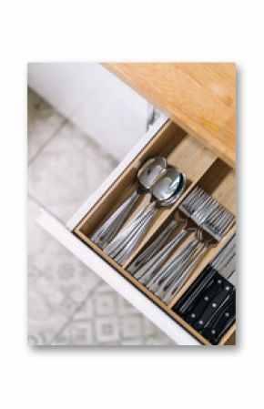 Modern kitchen drawer filled with cutlery and utensils in a stylish interior