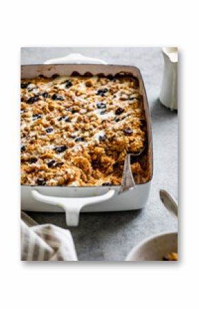 A baked oatmeal dish filled with nuts and dried fruits in a white casserole dish.