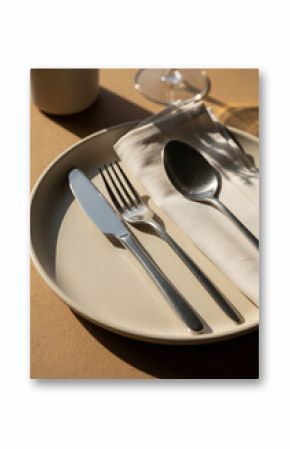 Minimal cutlery on ceramic plate with soft natural light