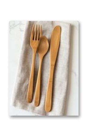 Wooden cutlery set on linen napkin, marble surface. Restaurant supplies