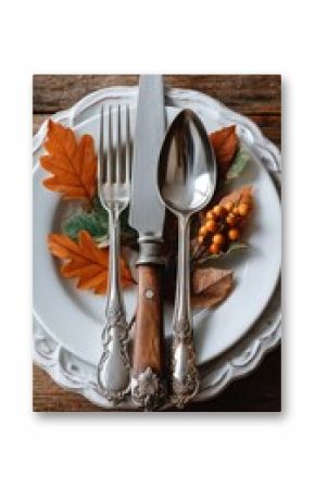 Beautifully arranged plates and silverware with autumn leaves for a seasonal dining experience during a cozy meal setting
