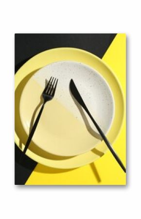 Stylish plates and cutlery on color background, top view