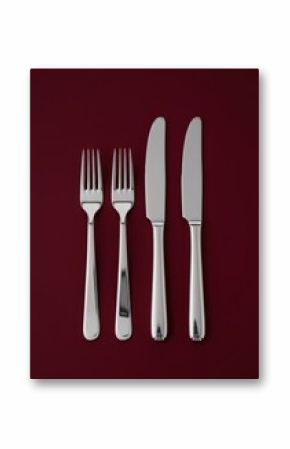 Polished Silver Fork and Knife on Flat Burgundy Background