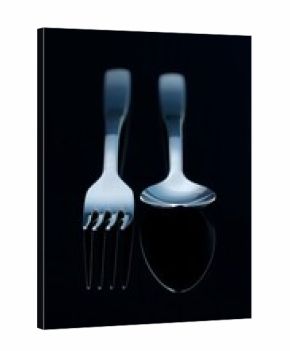 Two gleaming metallic cutlery items on a dark background