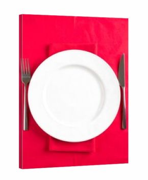 Empty white plate with cutlery on red tablecloth