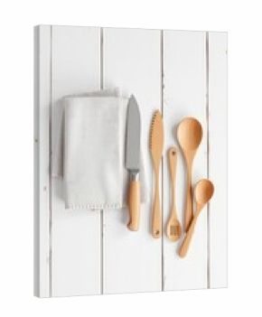 Kitchen Utensils Arranged Neatly on a Clean White Wooden Surface with a Neutral Linen Napkin Ready for Meal Preparation