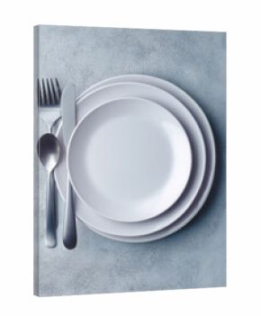 White plates with plastic utensils on textured grey surface.