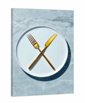 Minimal table setting with gold cutlery on white plate — stylish dining flat lay