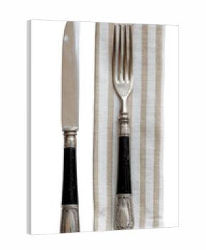 Silverware with dark handles on a striped napkin