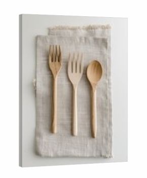 Three light-colored wooden utensils, two forks and a spoon, arranged on a light beige linen napkin, set against a bright white background.  The image is minimalist and clean