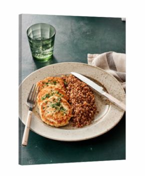 A plate features golden chicken patties alongside perfectly cooked buckwheat, showcasing a simple, satisfying meal perfect for lunch or dinner