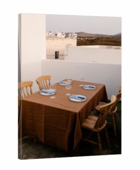 General view of a table set for dinner on the terrace of a house