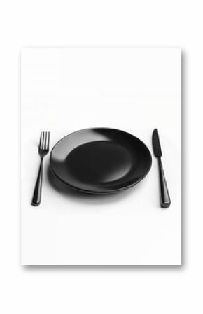 Black plate and cutlery set on white background for modern dining experience and elegant table setting