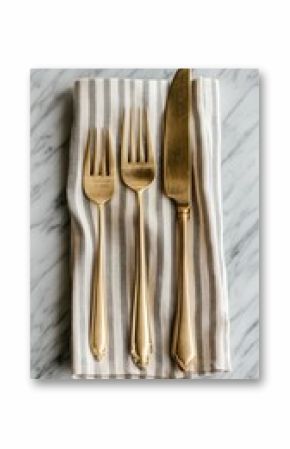 Golden Cutlery Set on Striped Napkin: Elegant Dining Essentials for a Stylish Table Setting