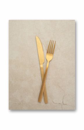 Set of golden metal cutlery on stone table