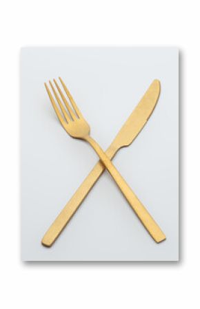 Set of golden metal cutlery on white background