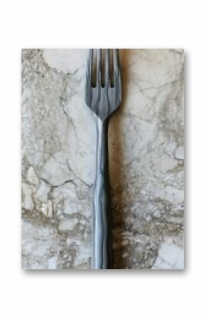 Grey fork with wood grain texture sits on a marble-like surface