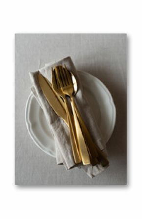 Golden cutlery with beige cotton napkins on the table. Knives, spoons and forks on a neutral cotton tablecloth. Table setting in a minimalist style