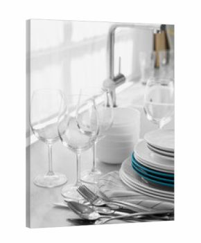 Different clean dishware, cutlery and glasses on countertop in kitchen
