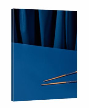 Wooden chopsticks set against a deep blue background with a blue curtain. Perfect for an Asian restaurant menu or a modern still life composition