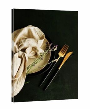 kitchen tableware top view on dark  background Plates,beige linen napkins, cutlery and lavender flowers . Space for text. Business food brand template. 