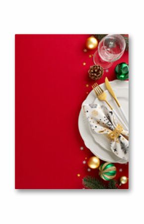 Transform your space: the road to a beautiful Christmas table. Top view vertical shot of cutlery, plates, glassware, fir twigs, tree ornaments, cones, stars confetti on red background with ad spot