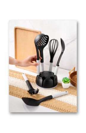 A hand is reaching a spoon from a cooking set, including whisk, skimmer, slotted spoon, square turner, and spaghetti server. They are nylon materials, non-stick cookware, high heat resistant