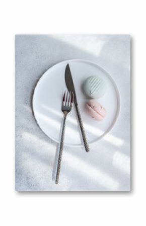 Elegant plate setup with pastel macarons and silver cutlery
